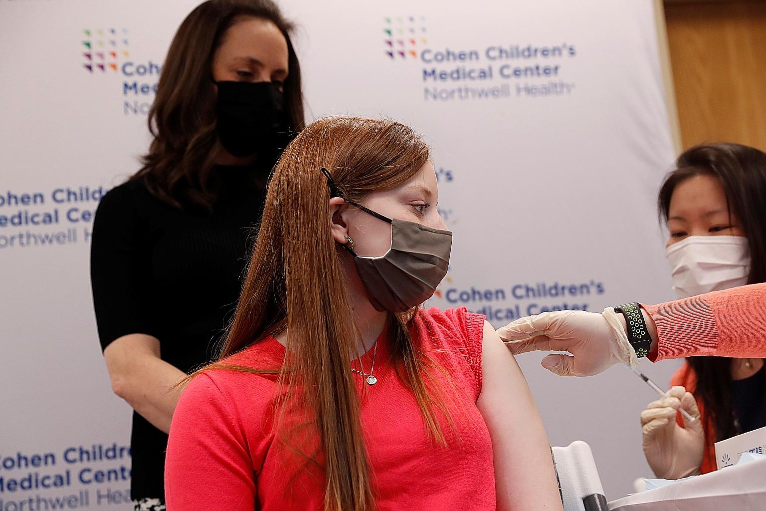 A 16-year-old girl receiving her first dose of the Pfizer-BioNTech vaccine last week in New Hyde Park village in New York. The Pfizer jab is not currently recommended for those under 16, while the Moderna shot is not approved for those under 18, but
