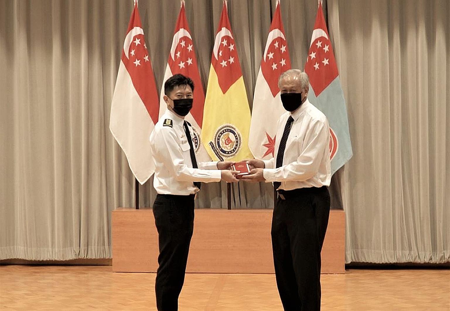 Colonel Teo Chin Leong receiving the Long Service Medal (Military) from Defence Minister Ng Eng Hen at the National Day Awards Investiture at the Ministry of Defence yesterday. Col Teo, who has spent nearly three decades in uniform, was among 770 Min