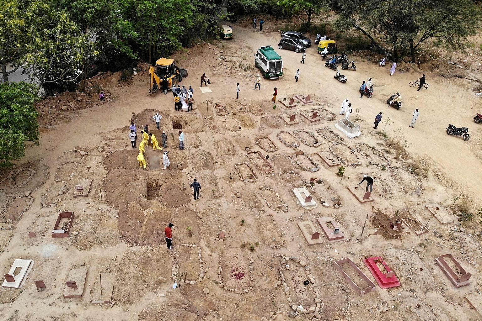 People preparing for the burial of relatives and friends who died from Covid-19 in New Delhi on Friday. The Indian capital led major cities across the country into a weekend lockdown yesterday as the country confronts a fierce new wave of the coronav