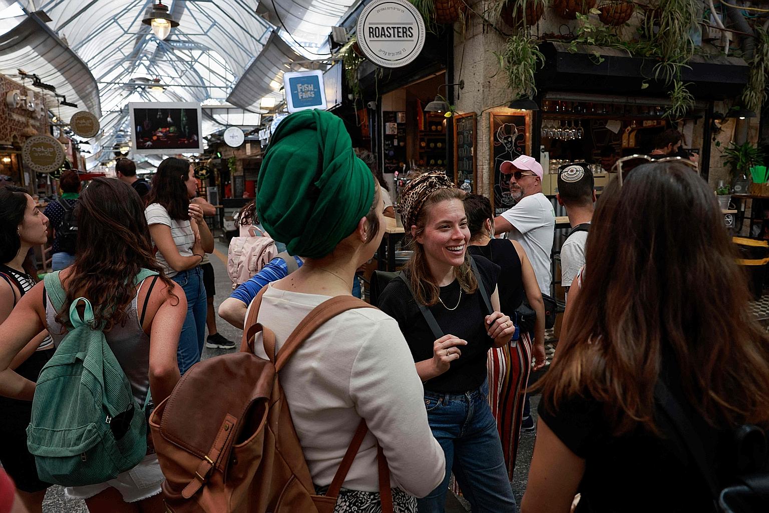 People at a market in Jerusalem yesterday after the Israeli authorities announced that face masks for Covid-19 prevention were no longer required outdoors. With over half the population fully vaccinated in one of the world's fastest anti-coronavirus