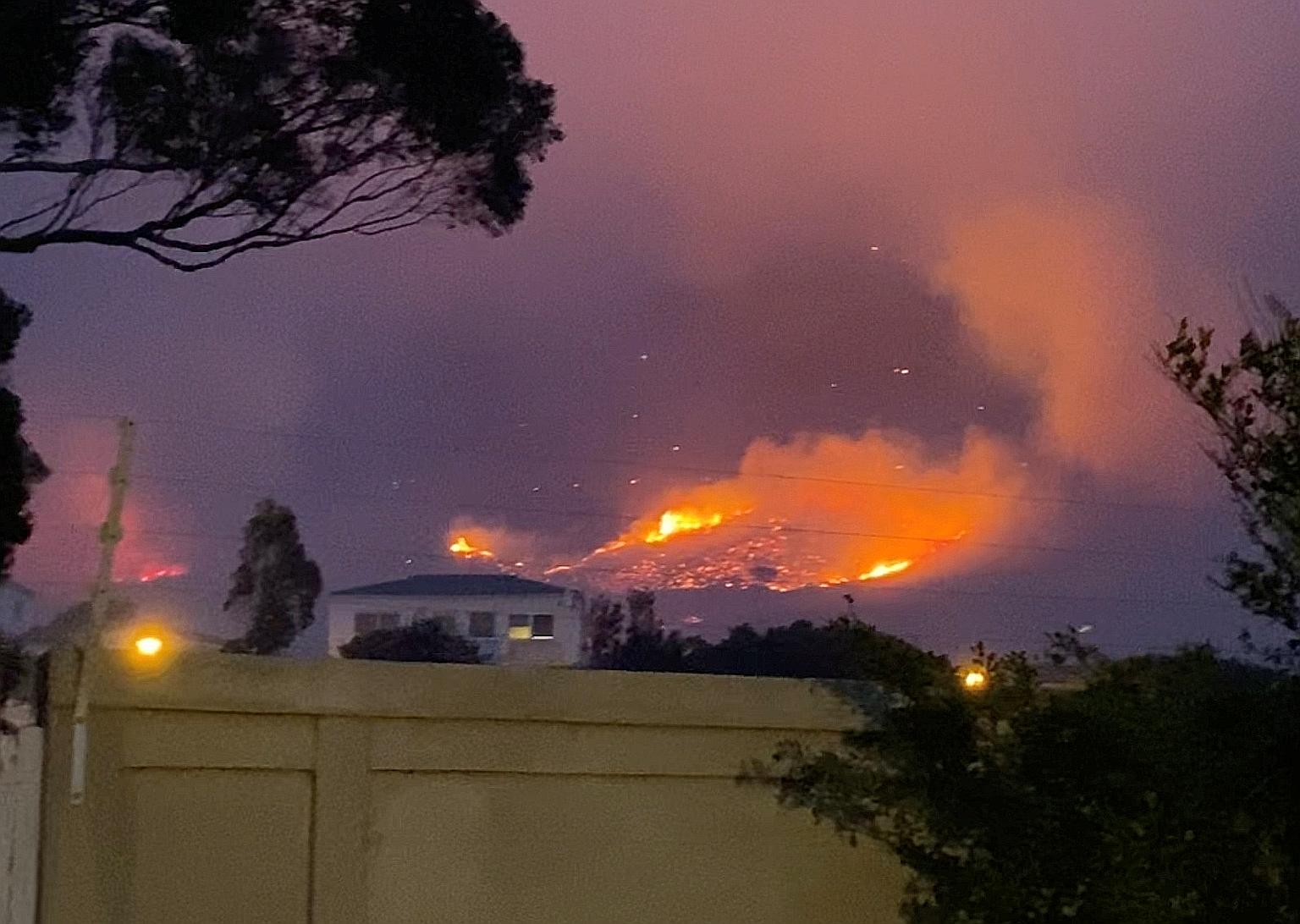 Smoke and flames from the wildfire on Table Mountain as seen from the Vredehoek suburb of Cape Town in South Africa yesterday.