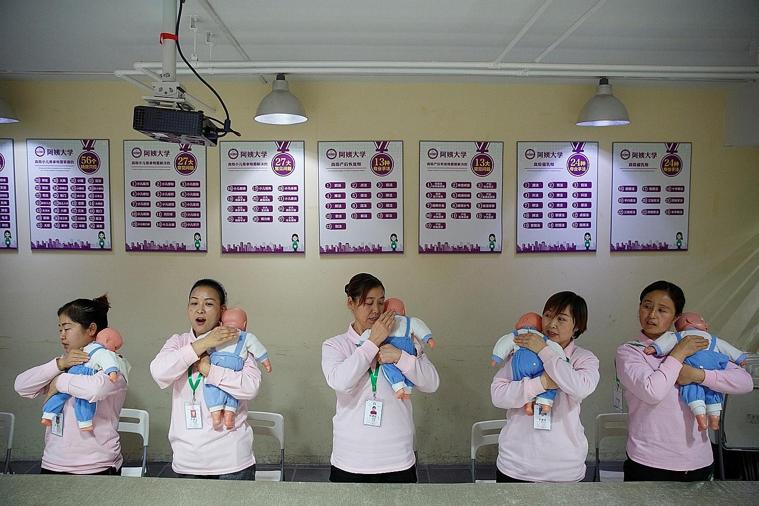 A file photo of students at a training programme for domestic helpers practising on dolls during a course teaching childcare in Beijing. The number of babies born in China fell by 580,000 to 14.65 million in 2019, and the birth rate of 10.48 per thou