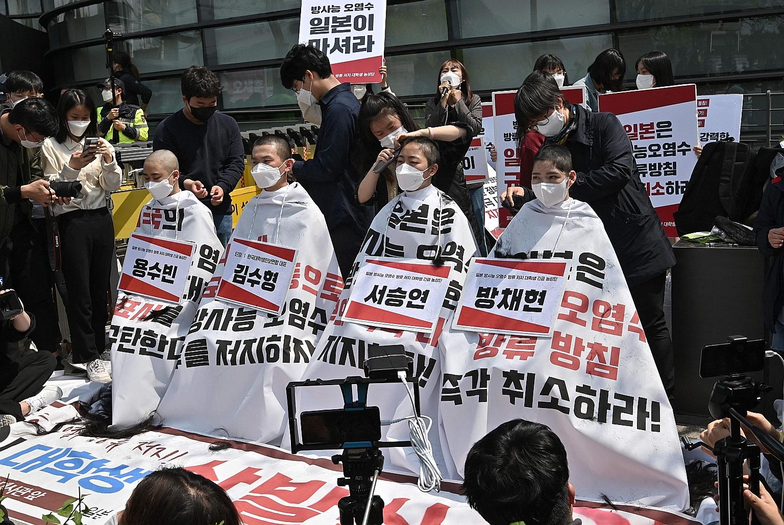 South Korean college students having their heads shaved outside the Japanese embassy in Seoul yesterday in protest against Japan's decision to release treated water from its crippled Fukushima nuclear plant into the sea. Japan last week said it will 
