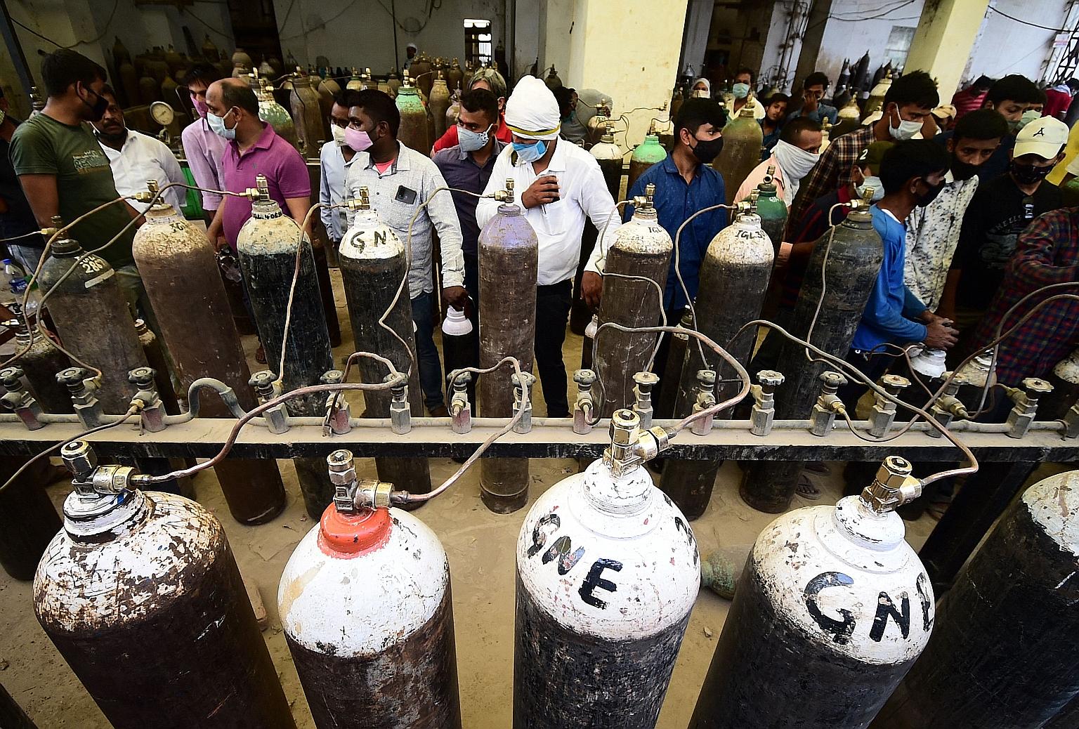 People filling cylinders with medical oxygen at a refilling station in Allahabad, India, on Tuesday. Families across the country have been struggling to find beds with oxygen supply in the past few days.