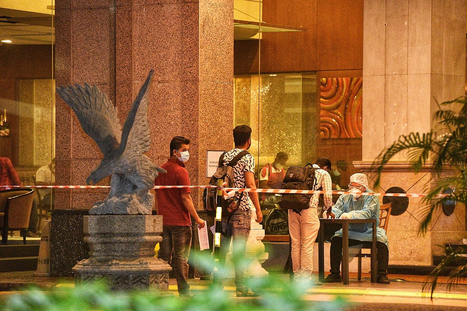 Migrant workers from Westlite Woodlands dormitory arriving at the Quality Hotel Marlow in Balestier Road yesterday. They were attended to by personnel wearing personal protective equipment.