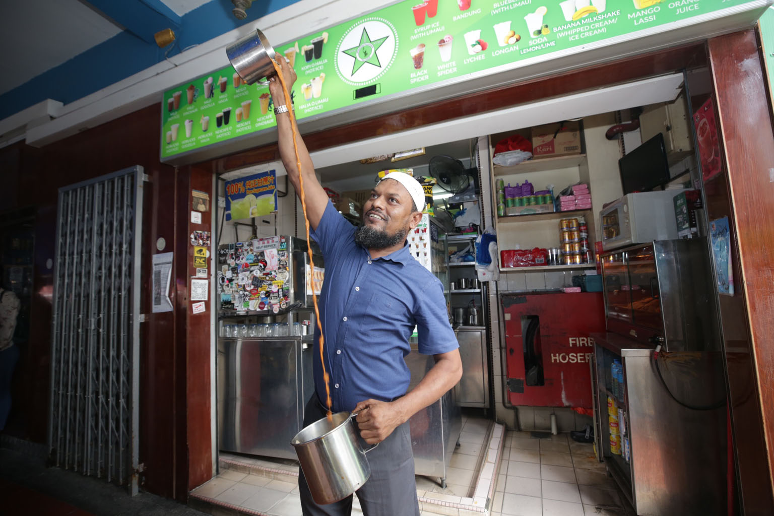 Mr Mohammad Asgar, the owner of food and beverage business Bhai Sarbat Singapore, demonstrating how he "pulls" his teh tarik to create a full head of froth.