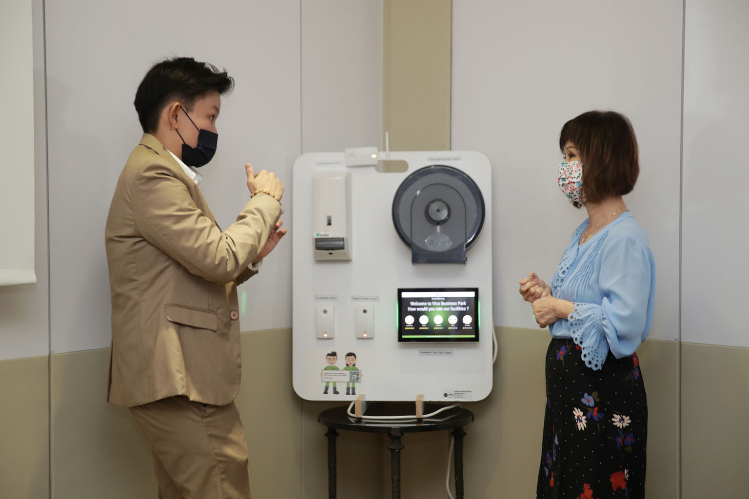 Mr Kelley Teo of Industrial and Commercial Facilities Management explaining to Senior Minister of State for Sustainability and the Environment Amy Khor how the company's smart toilet system works. ST PHOTO GIN TAY