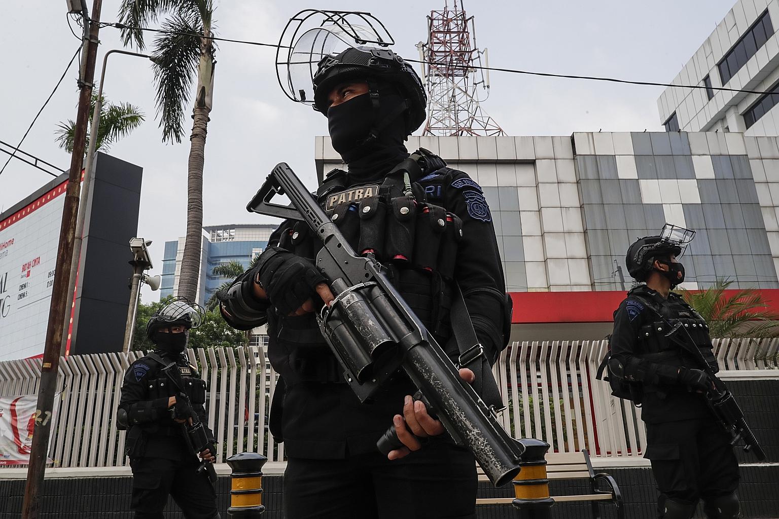 Police officers standing guard near the Asean secretariat in Jakarta yesterday. The regional grouping has a long history of "non-interference" in other members' internal affairs. Myanmar's seat at today's meeting will be filled by Senior General Min