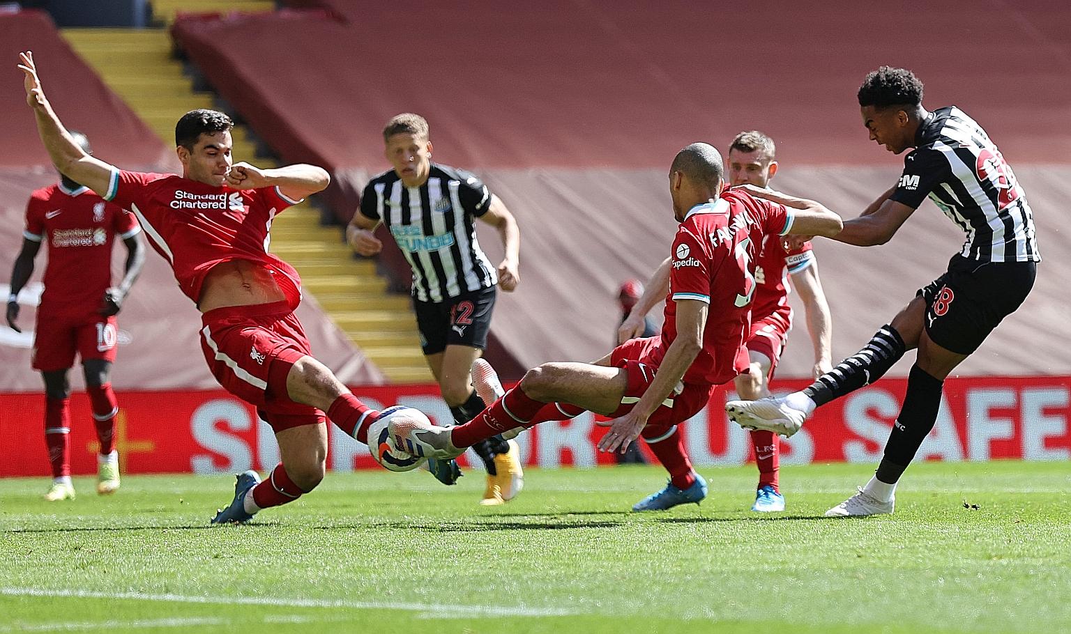 Newcastle's Joe Willock firing in his side's last-gasp equaliser past two Liverpool defenders in their 1-1 draw at Anfield yesterday.
