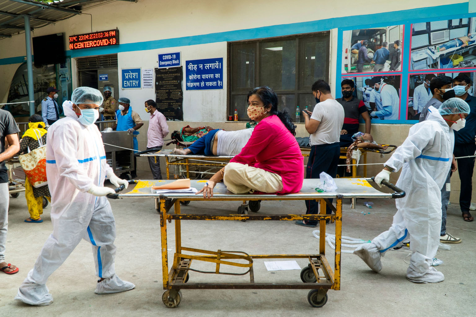 Staff transporting a Covid-19 patient in a hospital in New Delhi on Friday. India now records about 347,000 new infections every day. Its creaking healthcare system is on its knees. Over 2,500 people are dying every day.