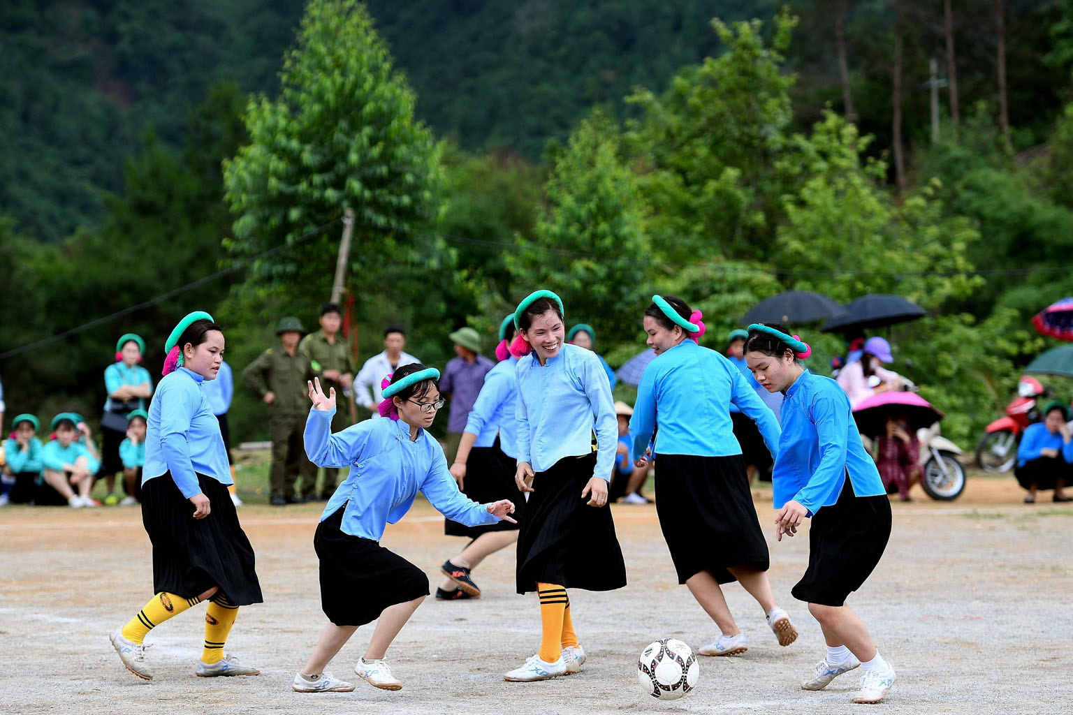 Farmers from the ethnic minority San Chi group, in Vietnam's Huc Dong commune, playing a friendly football match yesterday. The women's long-sleeved shirts, skirts and headbands have been, for generations, part of the traditional dress of their small