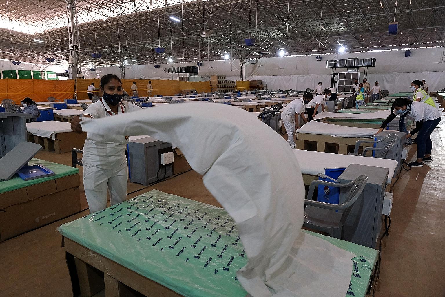 Workers preparing beds in a makeshift ward at the Sardar Patel Covid Care Centre in New Delhi at the weekend. Hospitals in India have had to turn away Covid-19 patients after running out of medical oxygen and beds. Daily cases have gone up eightfold