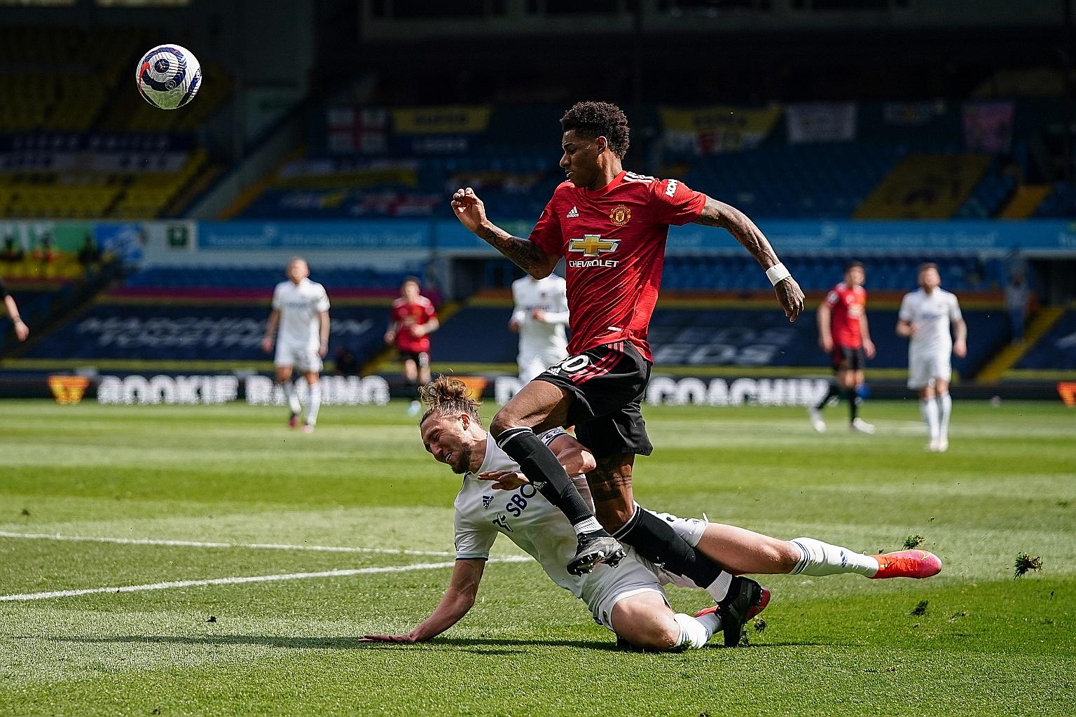 Leeds' Luke Ayling (in white) tackling Manchester United's Marcus Rashford in their Premier League encounter at Elland Road yesterday.