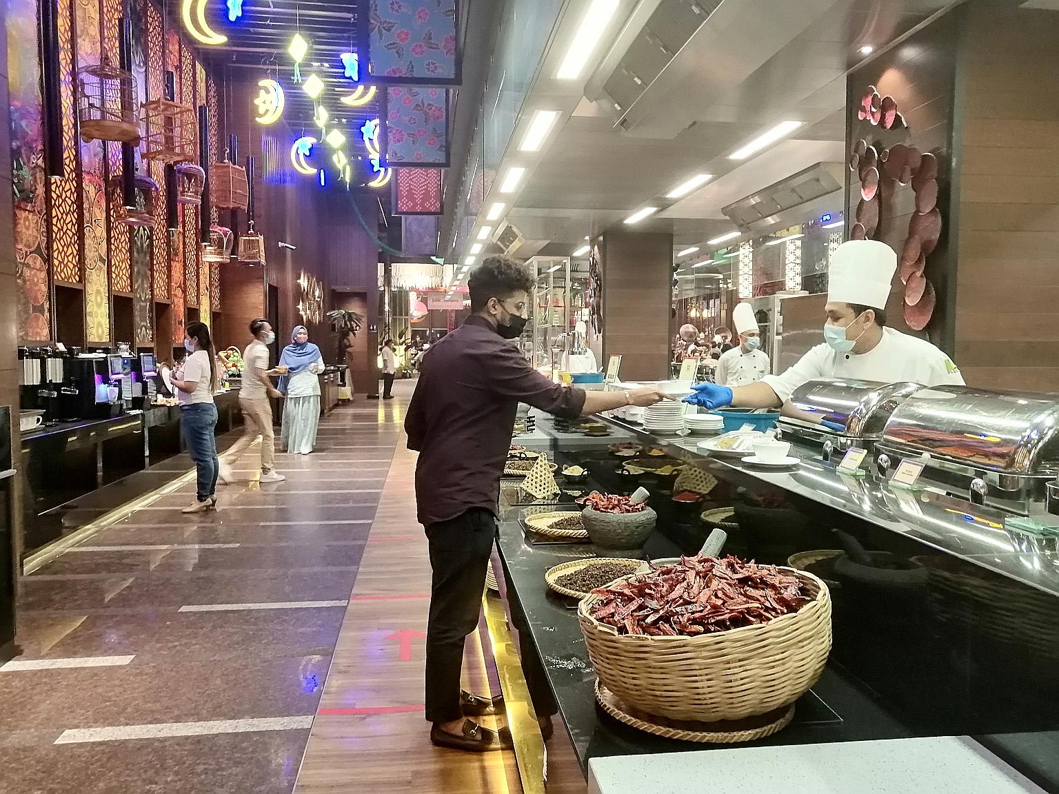 A chef at a buka puasa buffet at Sunway Resort, Malaysia, serving food to a guest as part of Covid-19 safety protocols. Hotels in the country are offering special Ramadan packages amid a ban on interstate travel because of the coronavirus outbreak. S