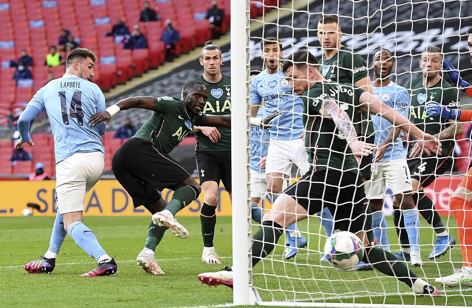 A late header from Aymeric Laporte (No. 14) gave Manchester City a 1-0 win over Tottenham in Sunday's League Cup final at Wembley. It earned Pep Guardiola his 30th trophy as a coach. PHOTO: EPA-EFE
