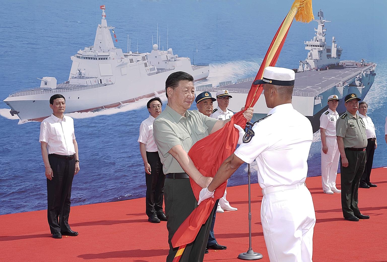 Chinese President Xi Jinping (centre) attending the commissioning ceremony of China's first advanced amphibious assault ship and two other new vessels at a naval port in southern China's Hainan province last Friday. PHOTO: XINHUA
