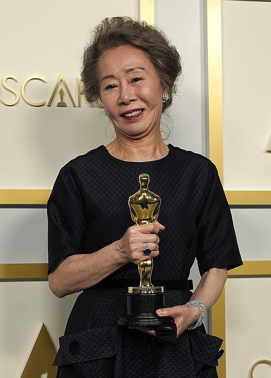 Chloe Zhao (above) accepting her Best Director award for the drama Nomadland at the Oscars in Los Angeles yesterday morning, Singapore time. Youn Yuh-jung (below) won Best Supporting Actress for her role in the immigrant drama Minari.