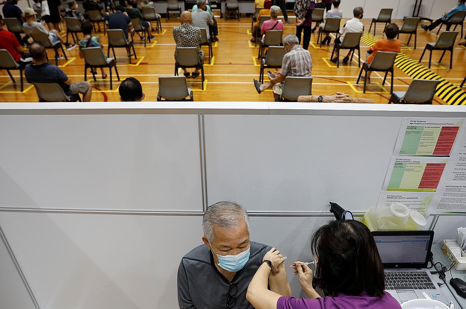 A man getting his Covid-19 vaccination at a centre in Singapore last month. Younger Singaporeans are more likely to be concerned about vaccine safety than those who are older, according to research released yesterday by the Institute of Policy Studie