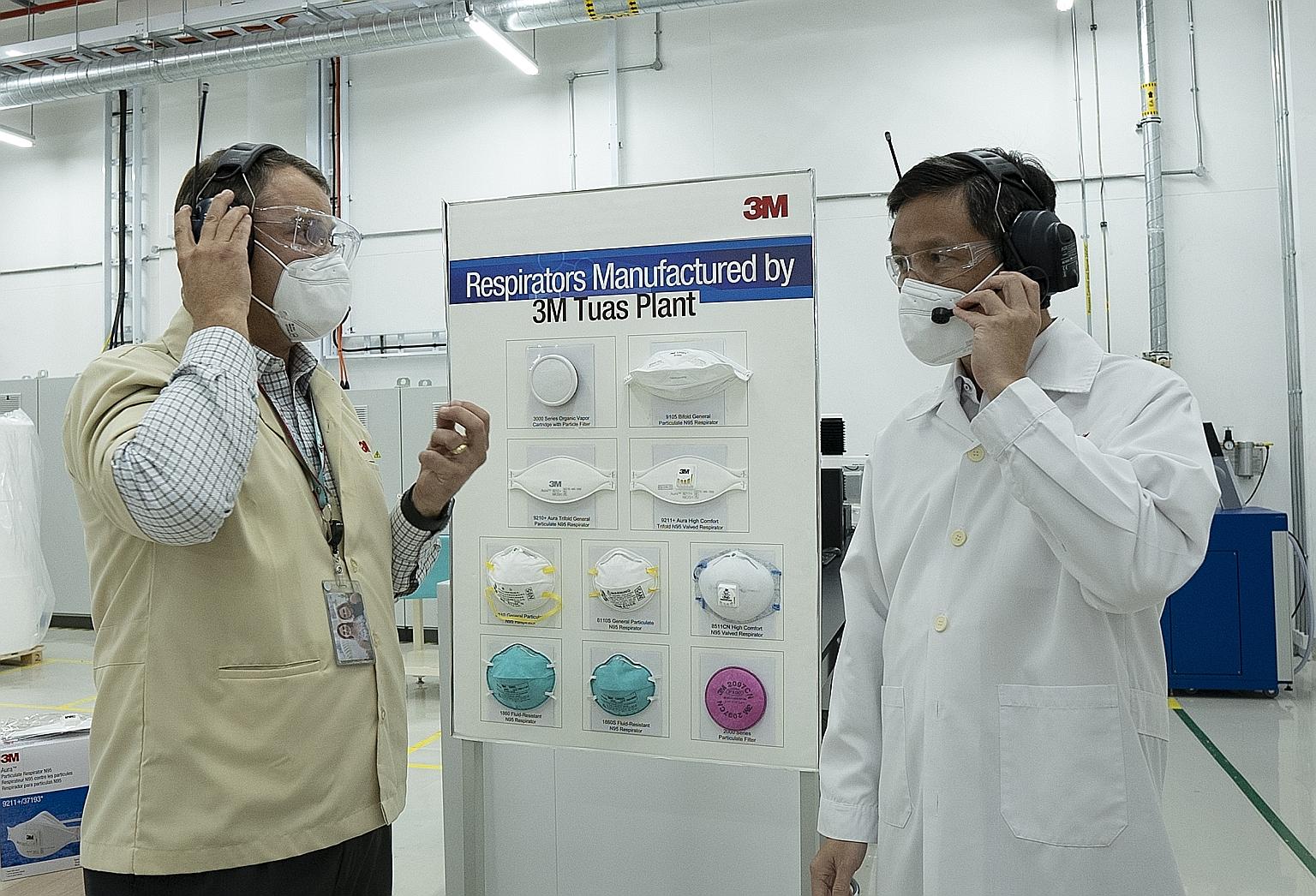 Mr Mark Ratzlaff (far left), director of plant operations at 3M Asia's transportation and electronics business group, showing Trade and Industry Minister Chan Chun Sing the respirators manufactured at 3M's facility in Tuas. PHOTO: 3M SINGAPORE