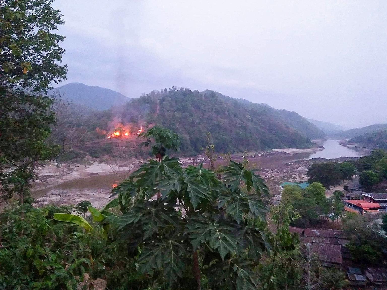 This handout from Kawthoolei Today shows fires burning yesterday at a Myanmar military base along the bank of the Salween river, as seen from Mae Sam Laep town in Thailand's Mae Hong Son province, after the base was attacked and captured by the Karen