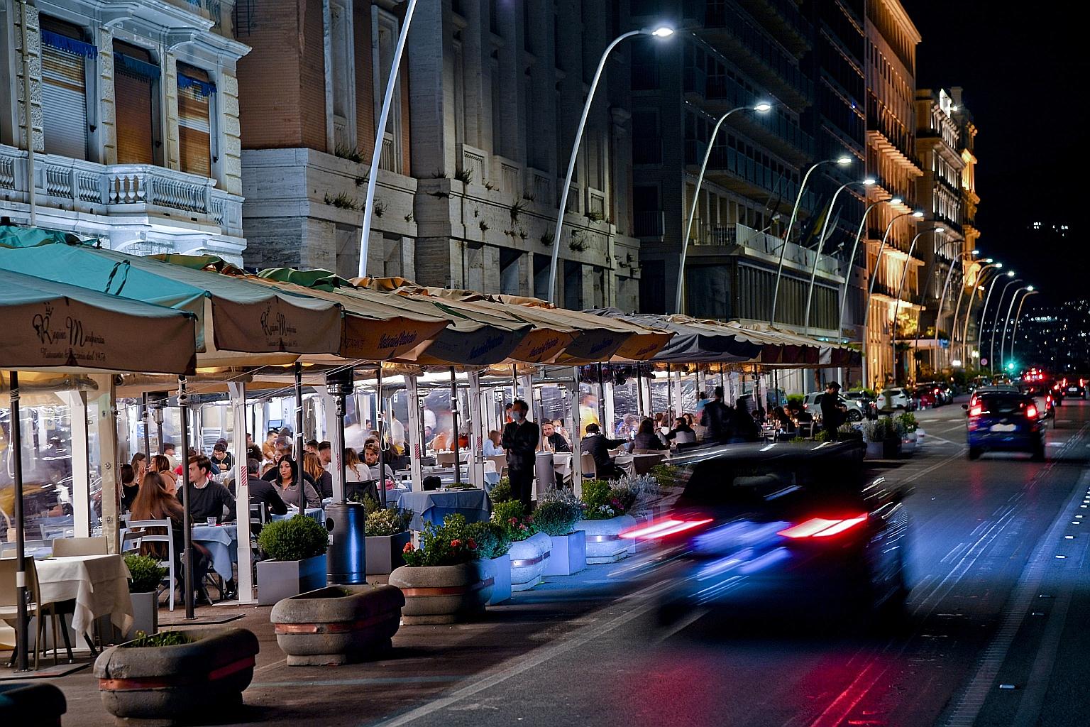 Customers in waterfront restaurants in Naples, Italy, on Monday - the first day of the easing of restrictions in the country after weeks of closure imposed by coronavirus pandemic rules.