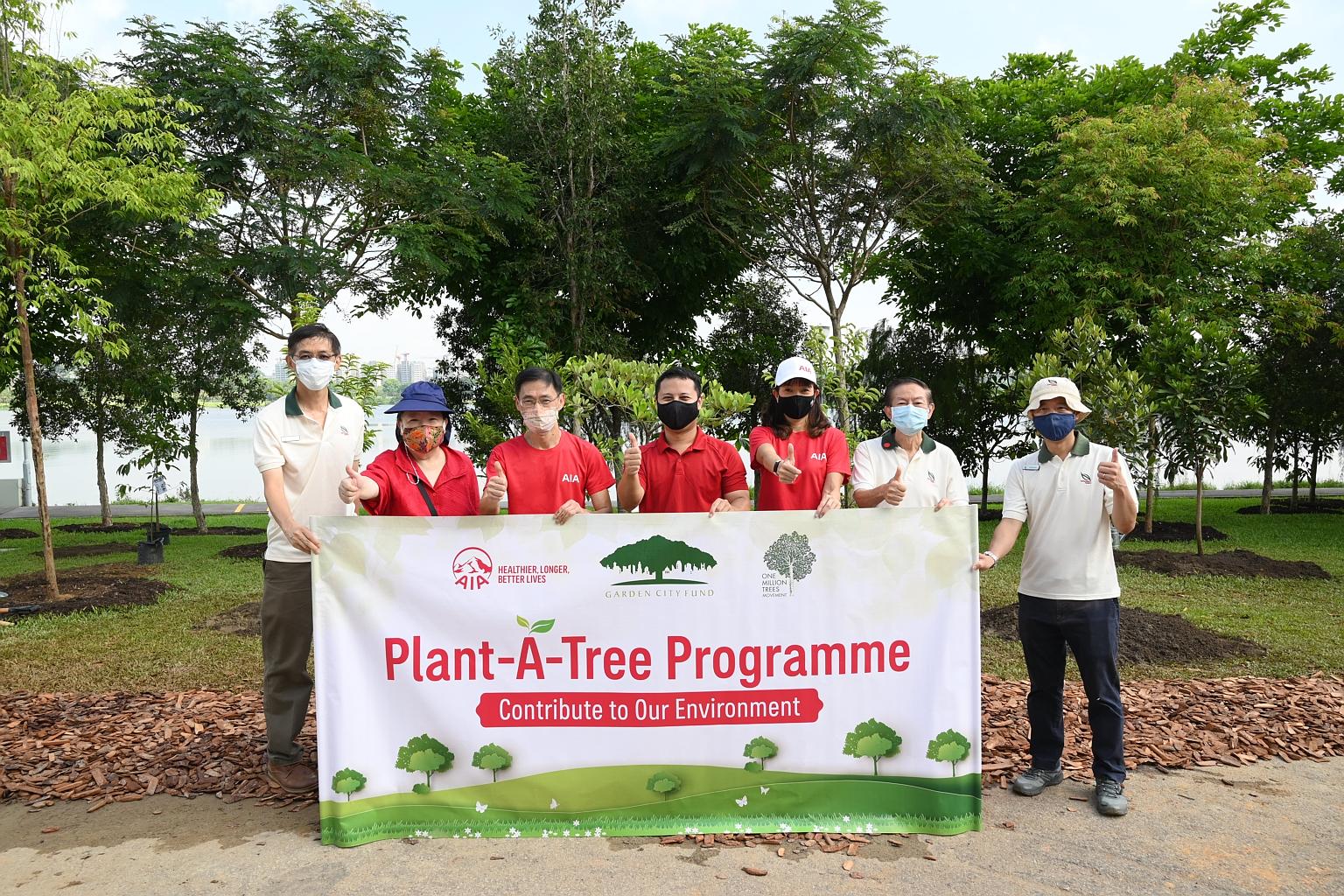 AIA and NParks staff, with National Development Minister Desmond Lee (centre), at yesterday's tree-planting event at Lower Seletar Reservoir.