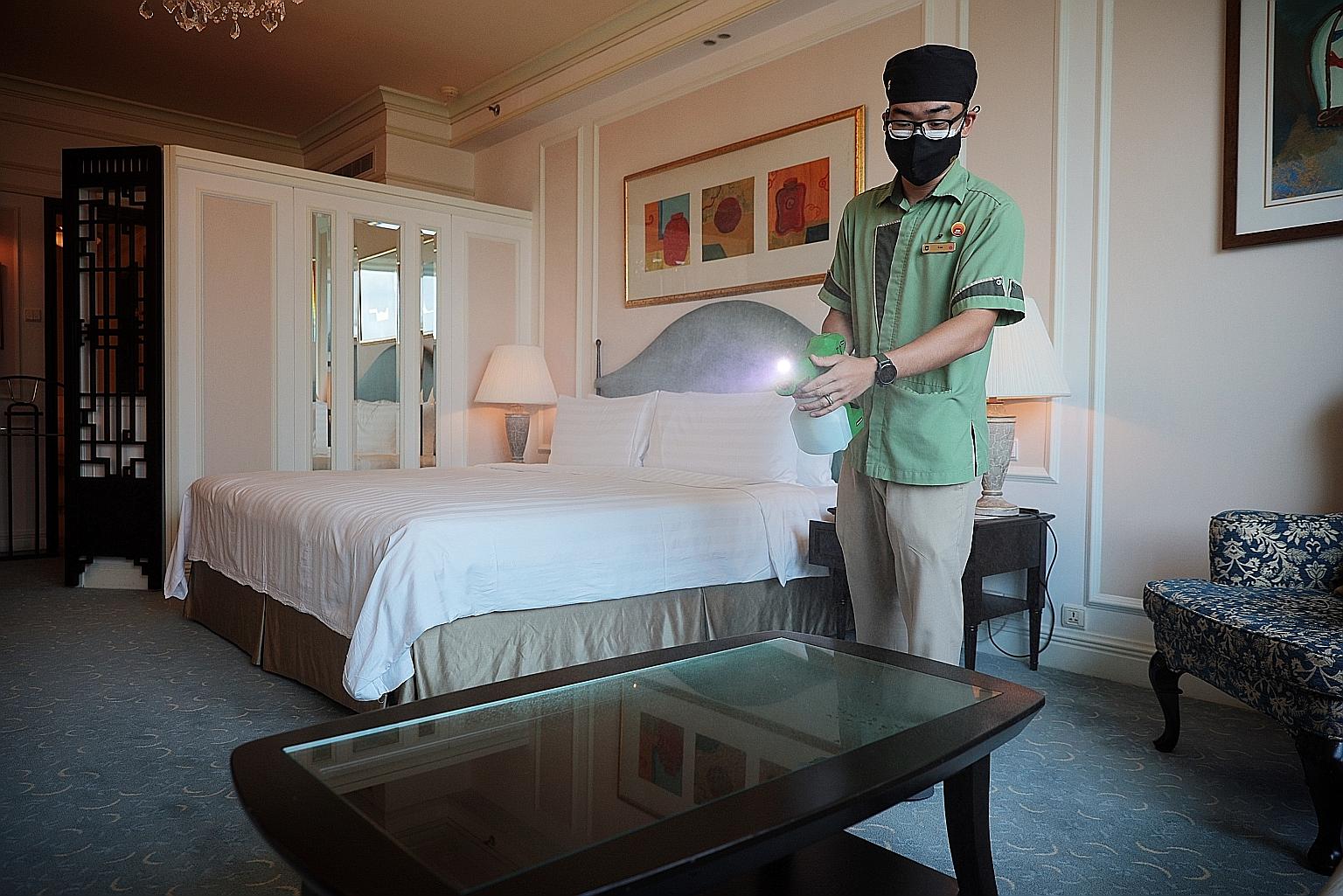 Assistant manager of housekeeping Le Nguyen Dang Khoa, 25, disinfecting a room at Shangri-La Hotel Singapore. Amid the challenges of the Covid-19 outbreak last year, the hotel prioritised cutting non-essential expenses over trimming labour costs. ST 