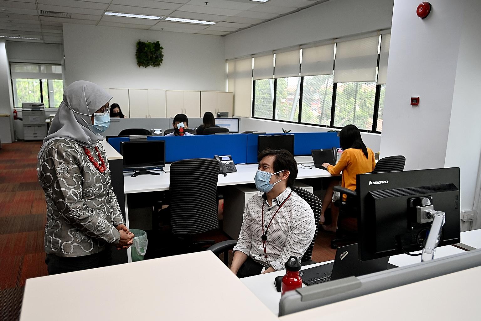 President Halimah Yacob stopped to chat with Mr Maximillian Tan, seated at his height-adjustable work desk, during her visit to Cushman and Wakefield Services yesterday. The company, which currently employs eight persons with disabilities, is aiming 