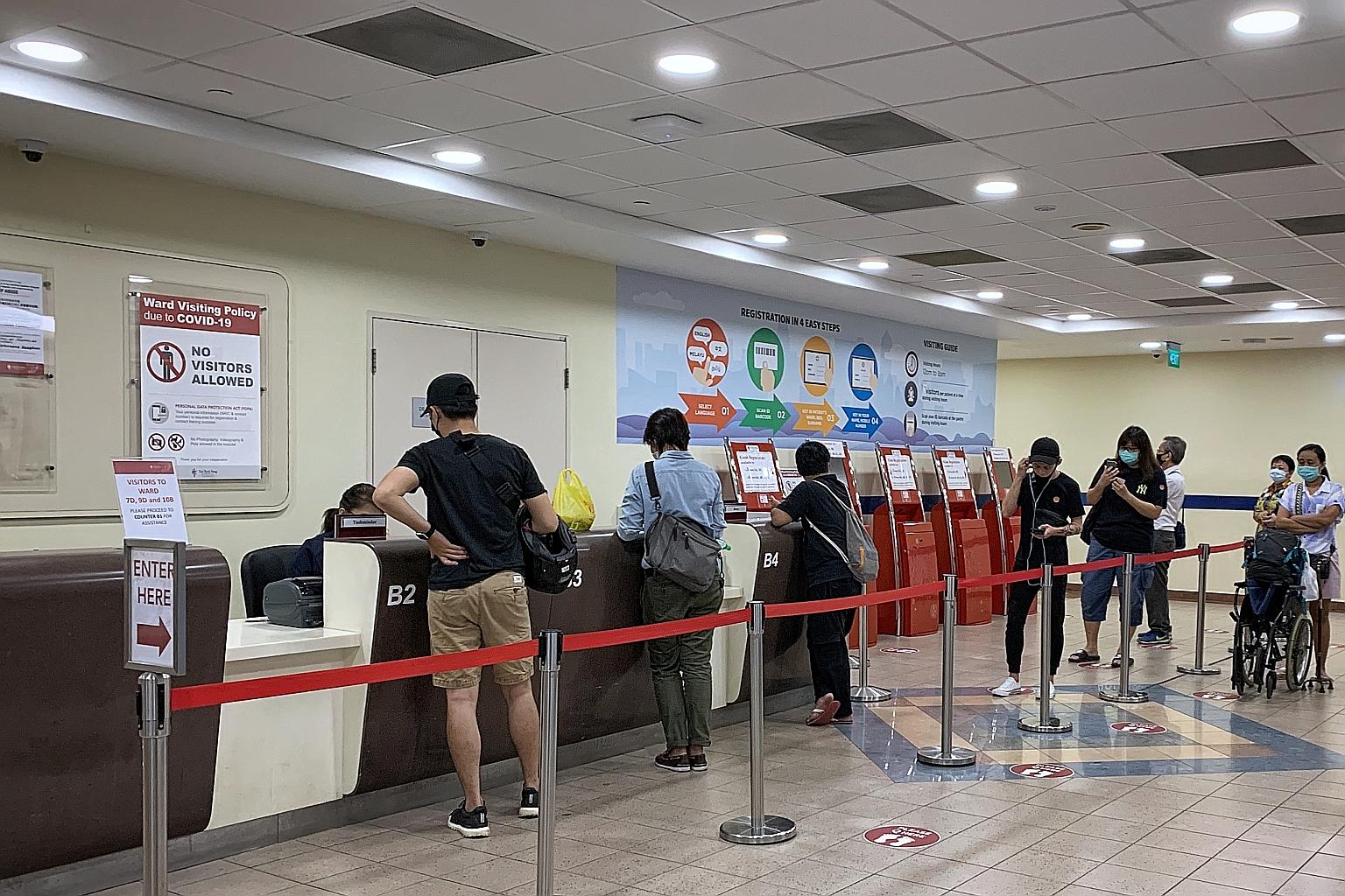 People at the visitor registration counter in Tan Tock Seng Hospital yesterday. No visitors are allowed into the hospital except those for critically ill patients.