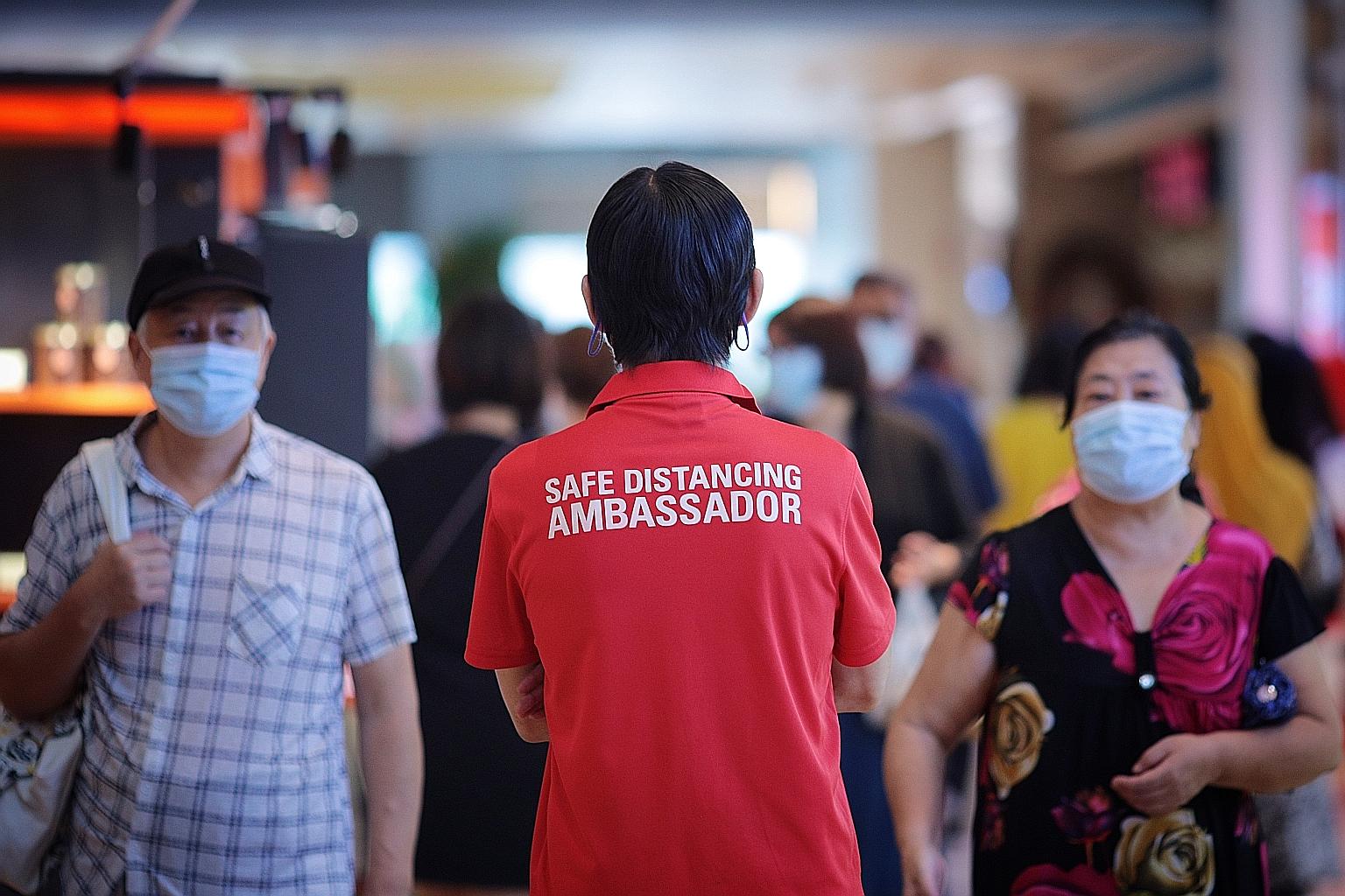 A safe distancing ambassador at Velocity mall in January. Agencies will step up enforcement checks amid a rise in Covid-19 transmissions. ST FILE PHOTO