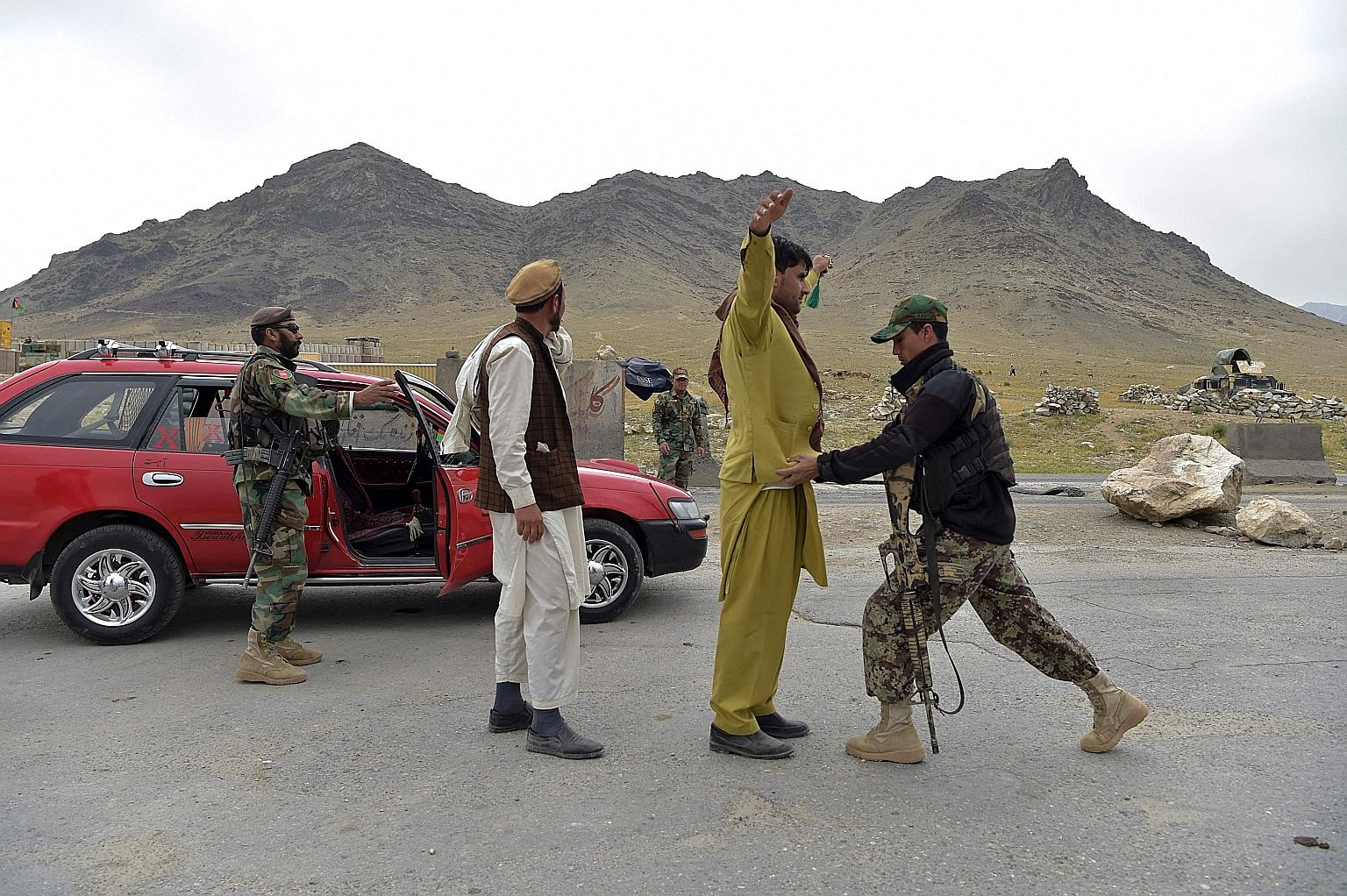 Afghan National Army soldiers conducting a search on travellers at a road checkpoint on the outskirts of Kabul on Thursday. The US has said it is temporarily deploying extra troops to protect international forces as they withdraw, and has prolonged t