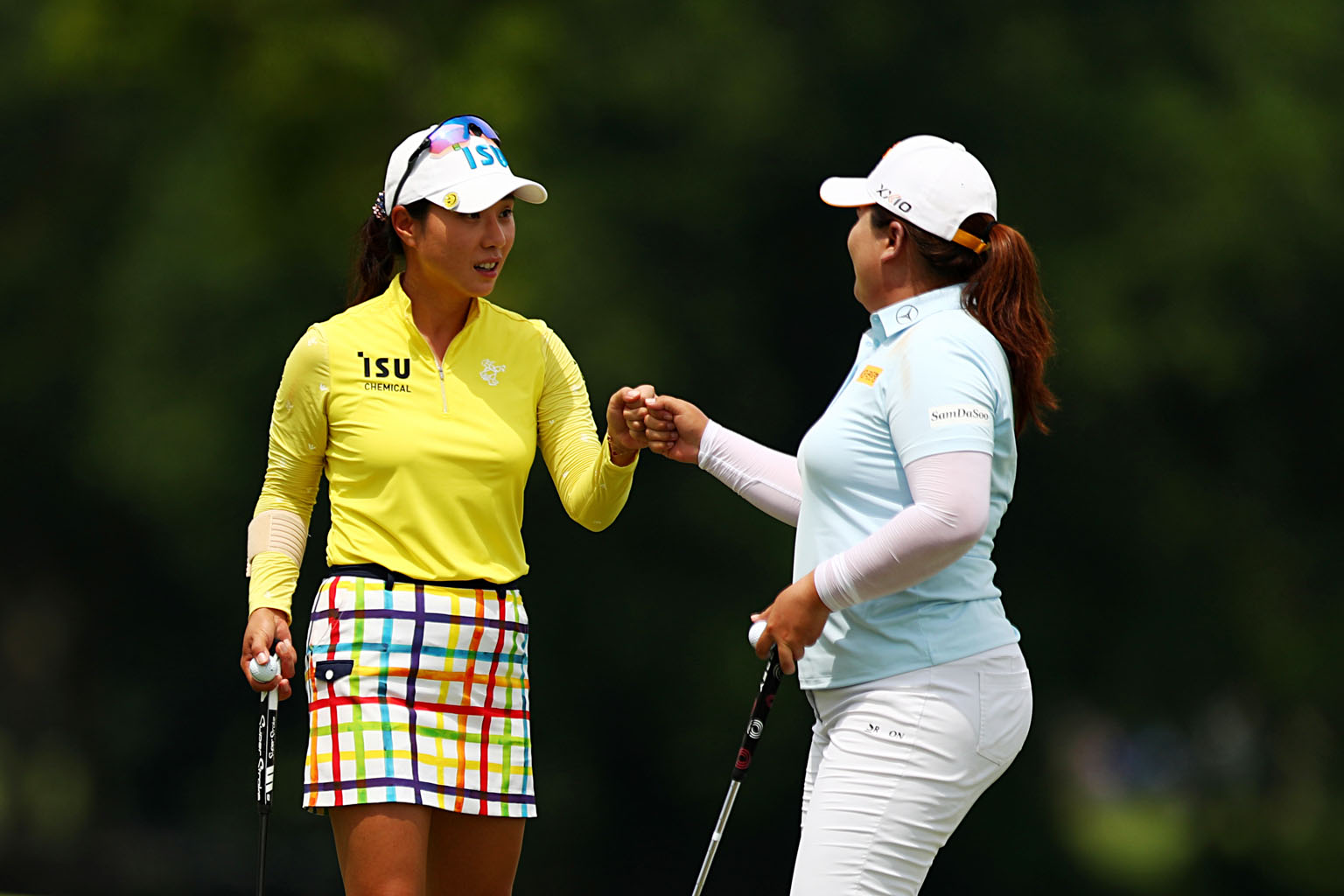 Park Hee-young (left) and Park In-bee bumping fists after completing the second round of the HSBC Women's World Championship at Sentosa Golf Club yesterday. Hee-young birdied the final hole for a four-under 68, one better than the 69 of In-bee, who w