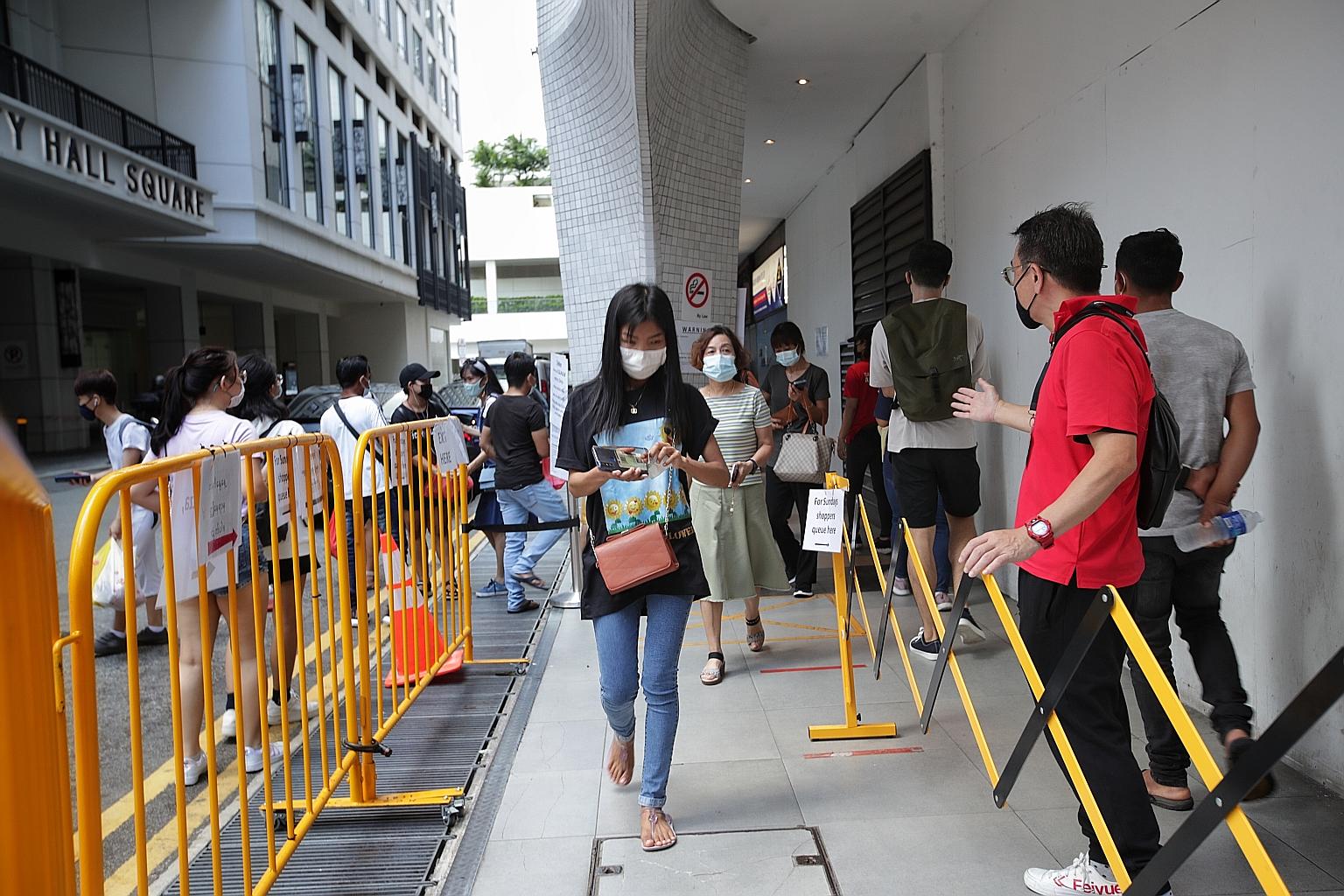 Shoppers queueing to enter Peninsula Plaza yesterday. The restrictions on Sundays let only those whose identification numbers end in even digits visit on even dates, while those whose numbers end in odd digits visit on odd dates. ST PHOTO: GIN TAY