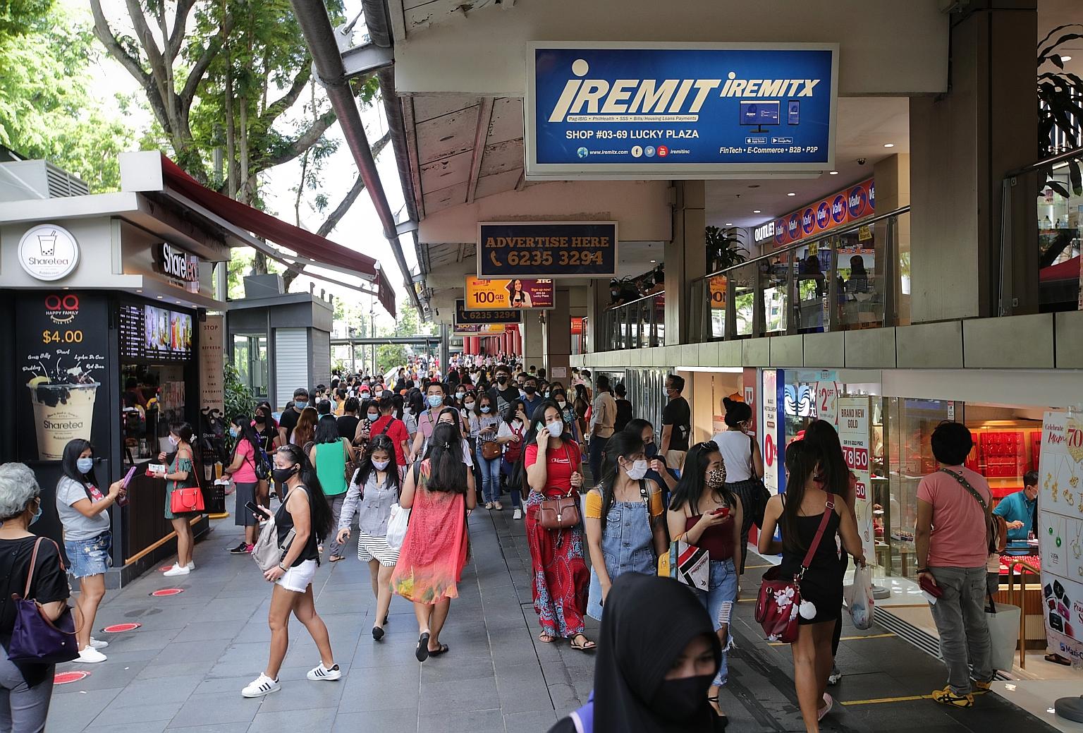 There were fewer people inside Lucky Plaza (above) and Peninsula Plaza yesterday, as entry restrictions kicked in amid a rise in Covid-19 cases in Singapore. But it was a different story outside the malls, where safe distancing seemed to take a back