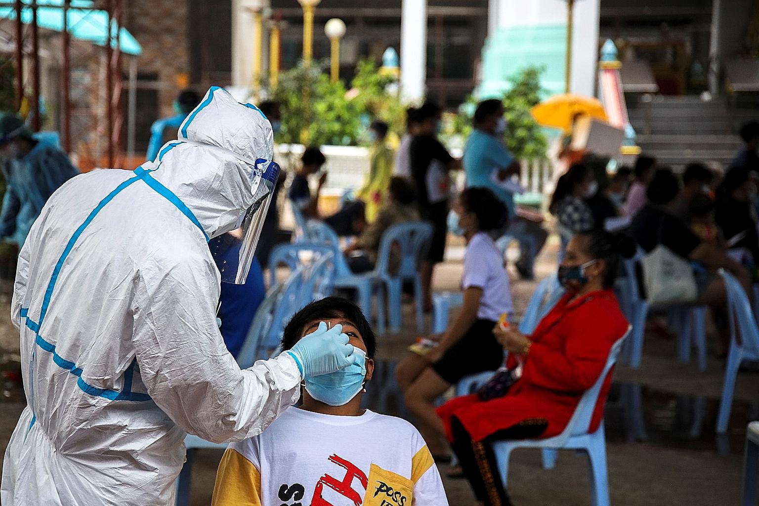 A swab test being administered in Bangkok yesterday. The new outbreak has accounted for more than half of total cases and deaths in Thailand since the start of the pandemic.