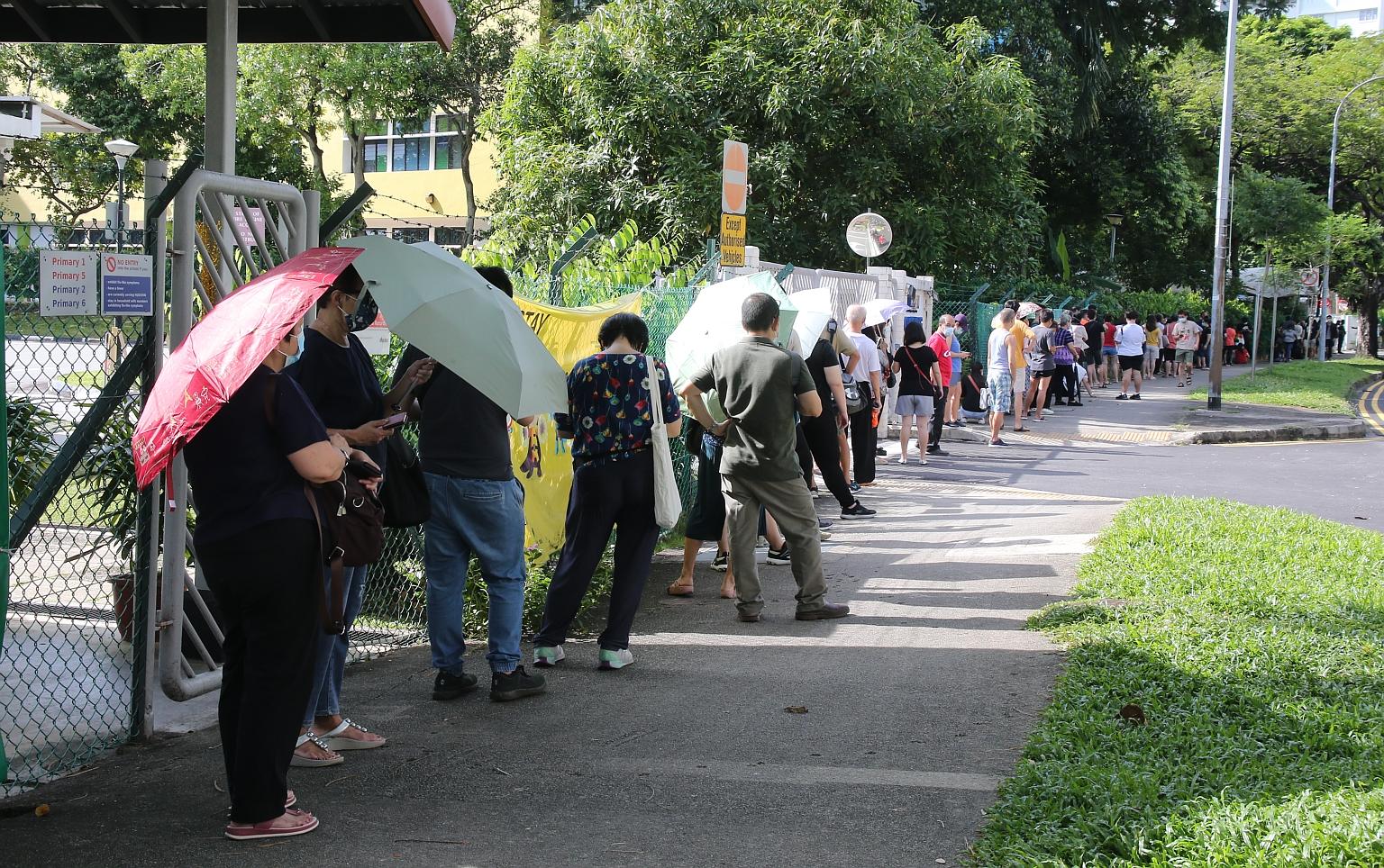 QUEUE AT REGIONAL SCREENING CENTRE: People queueing to get tested for Covid-19 yesterday at the former Da Qiao Primary School in Ang Mo Kio, one of four regional screening centres designated for free testing for people with possible exposure to the T