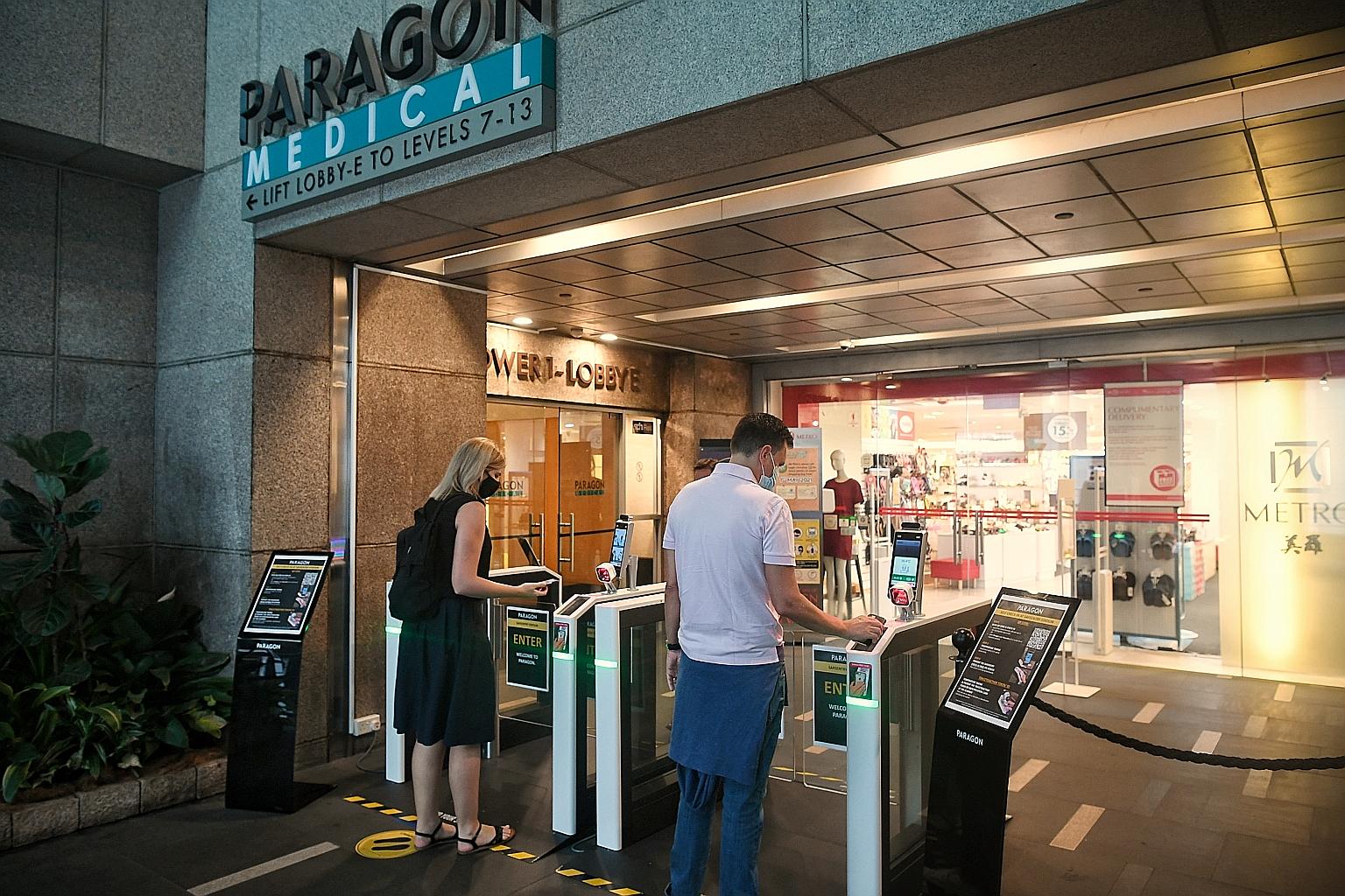 Shoppers using electronic gantries at Paragon Shopping Centre to verify their SafeEntry check-ins yesterday. From May 17, more venues including malls, schools and workplaces must implement TraceTogether-only check-ins. ST PHOTO: KUA CHEE SIONG