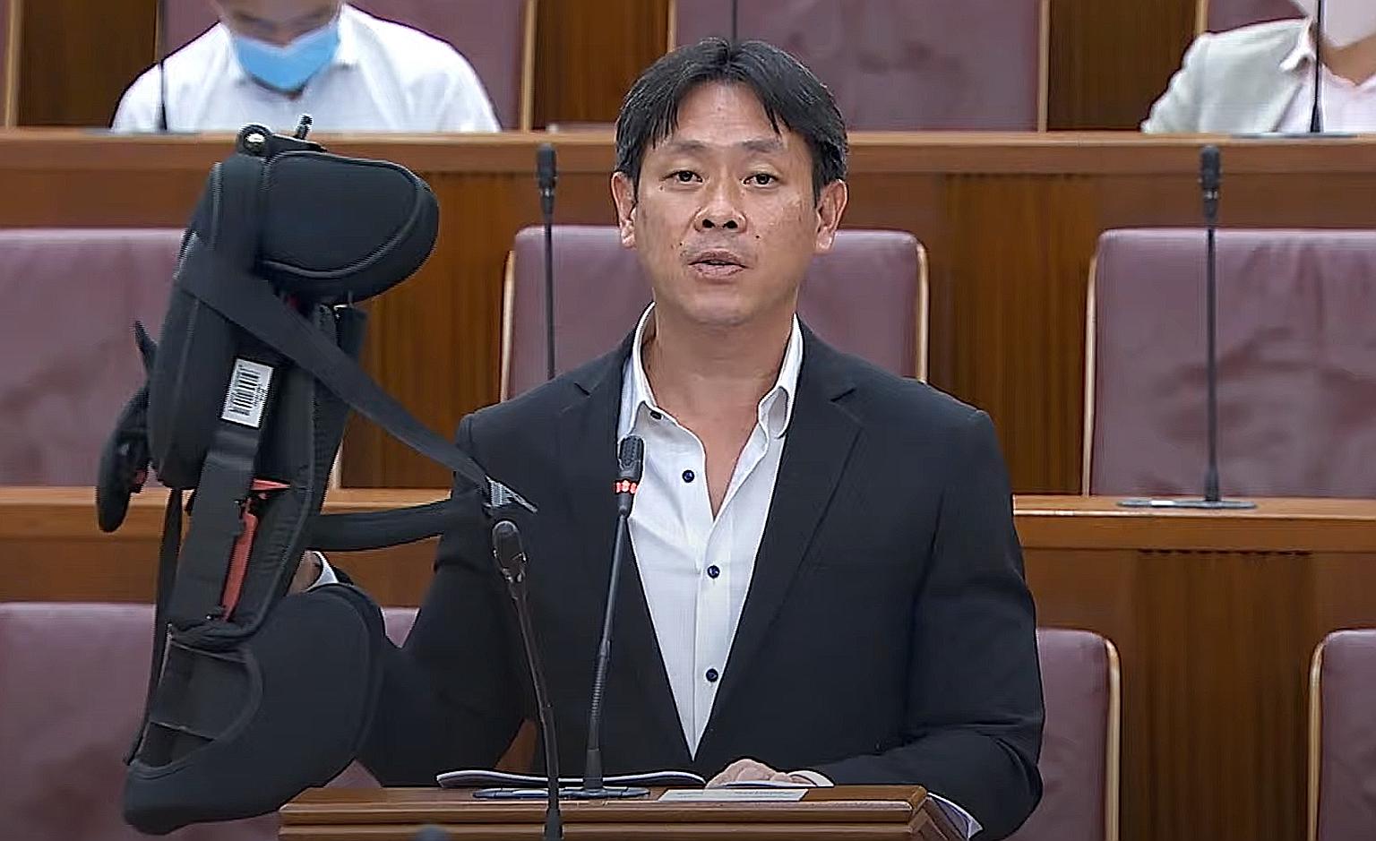 Mr Louis Ng (Nee Soon GRC) holding up a child's car seat in Parliament yesterday. He suggested providing one car seat for children aged nine months to four years, and another for those aged above four years. PHOTO: MCI