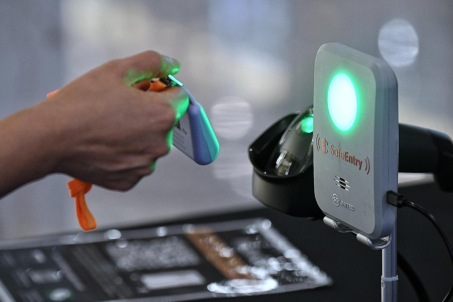 As at end-April, about 92 per cent of the population above the age of six were on board TraceTogether, which makes use of a Bluetooth-enabled app or token (left) for contact tracing. ST PHOTO: KUA CHEE SIONG