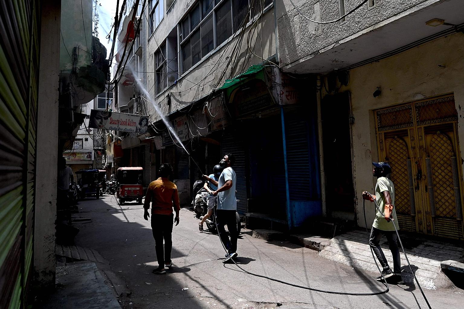 Workers disinfecting a street in New Delhi yesterday. India, with a population of 1.4 billion, accounts for half of all virus cases reported globally last week and 30 per cent of deaths worldwide, the World Health Organisation said in its latest repo