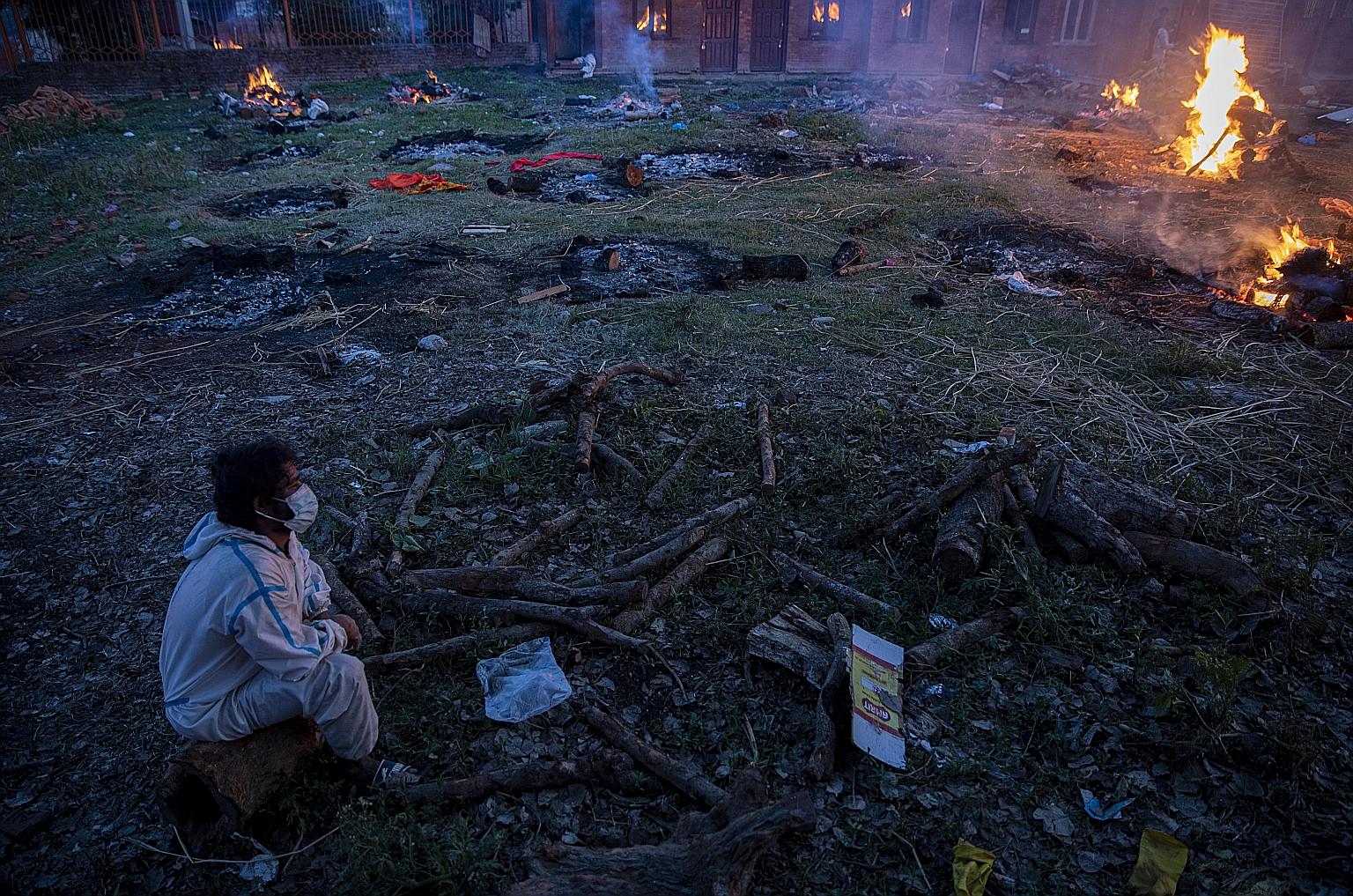 A man amid the funeral pyres of coronavirus victims in Kathmandu, Nepal, on Tuesday. The Independent Panel for Pandemic Preparedness and Response says the threat of a pandemic had been overlooked and countries were woefully unprepared to deal with on