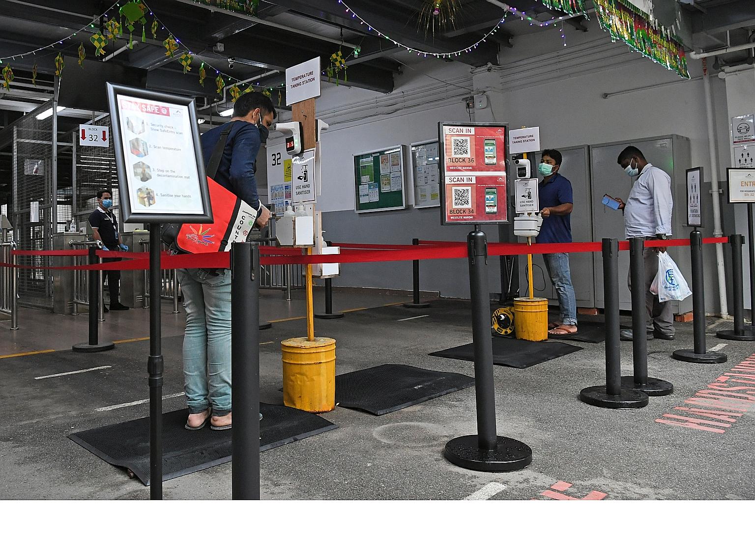 Westlite Mandai dormitory residents taking their temperature and checking in using SafeEntry last month. While it is not possible to stamp out fully the possibility of reinfection clusters, workers are now more resilient. ST PHOTO: DESMOND FOO