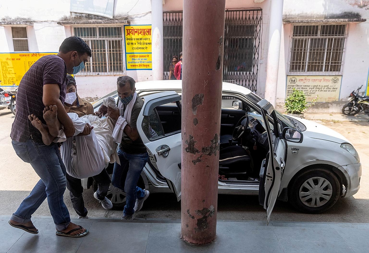 Men carrying a 77-year-old relative experiencing breathing problems to a government-run hospital for treatment, in Uttar Pradesh, India, on Tuesday. Two-thirds of people in the country live in rural towns and villages where healthcare facilities are 