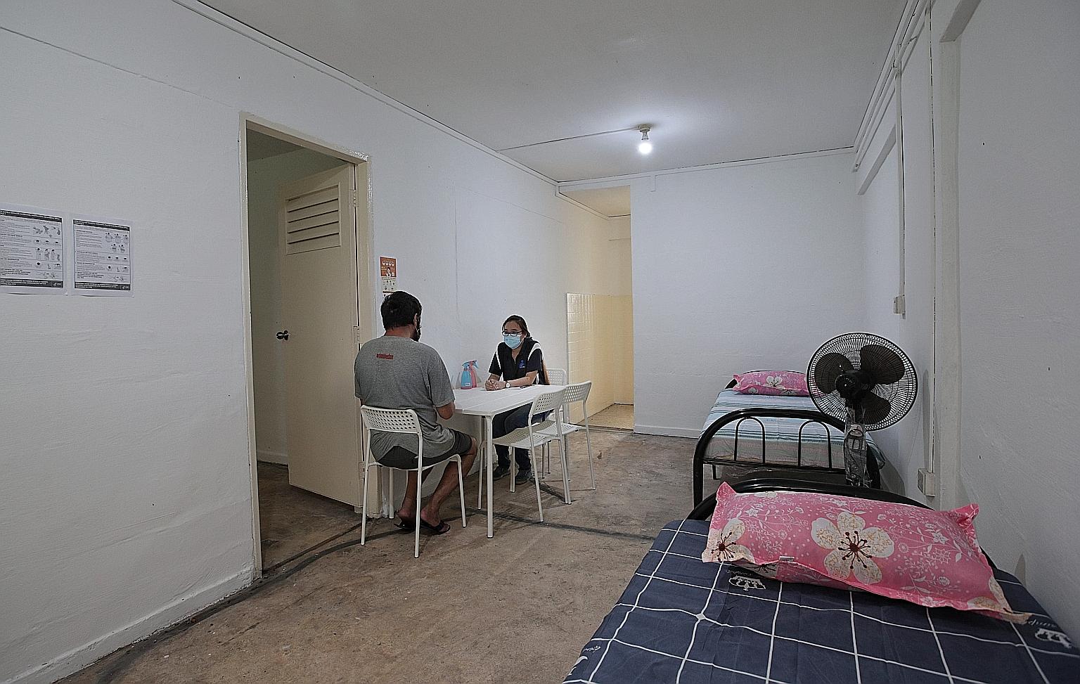 Ms Jessica Ong, senior social worker at AMKFSC Community Services, speaking to Mr Wong, who has been staying since January at a new transitional shelter run by the charity. Transitional shelters, funded by the Government, provide a longer-term stay t