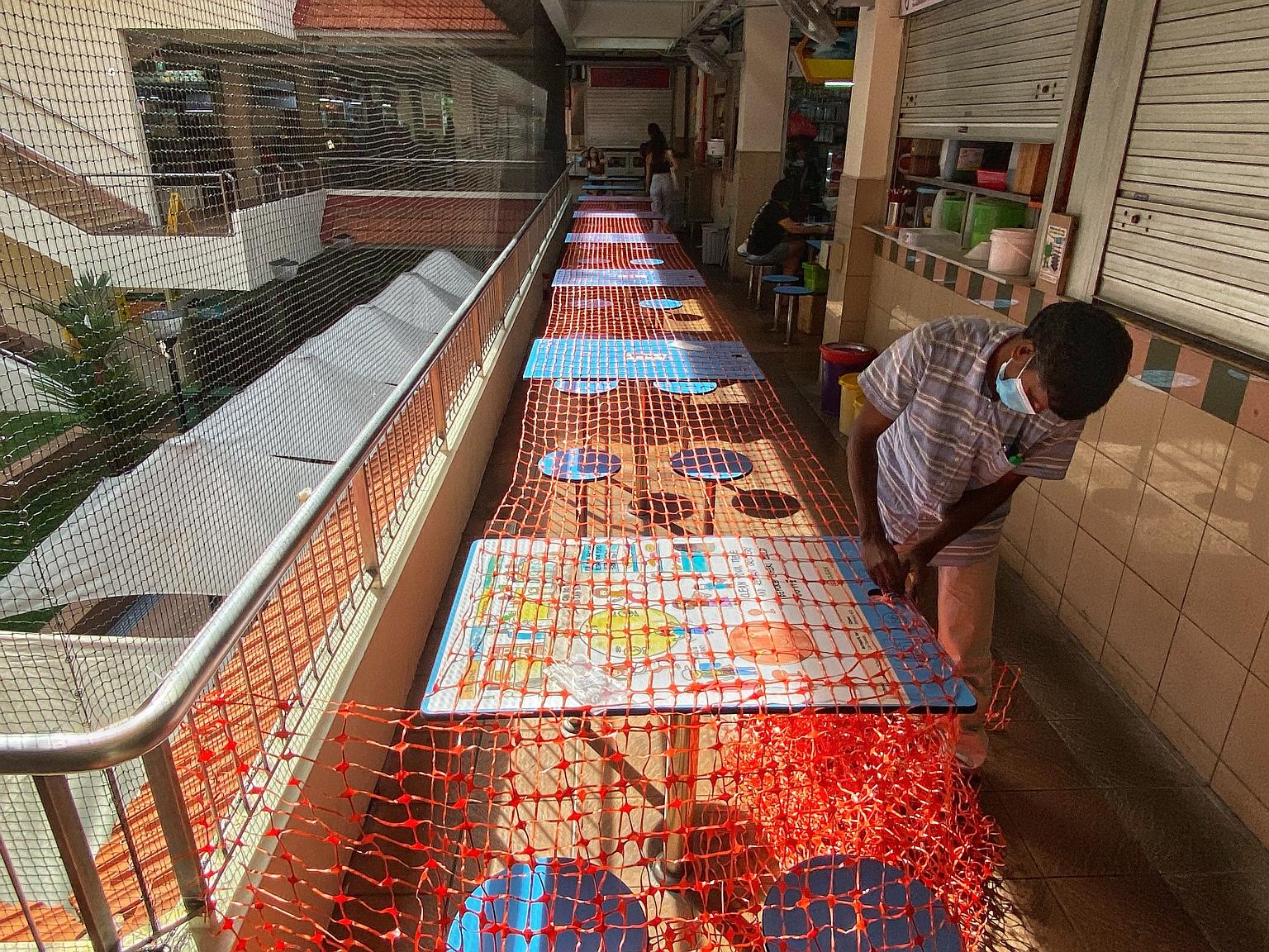 Tables and chairs being fenced up at Golden Mile Food Centre yesterday. Dining in, including at hawker centres and foodcourts, will not be allowed from today until June 13.