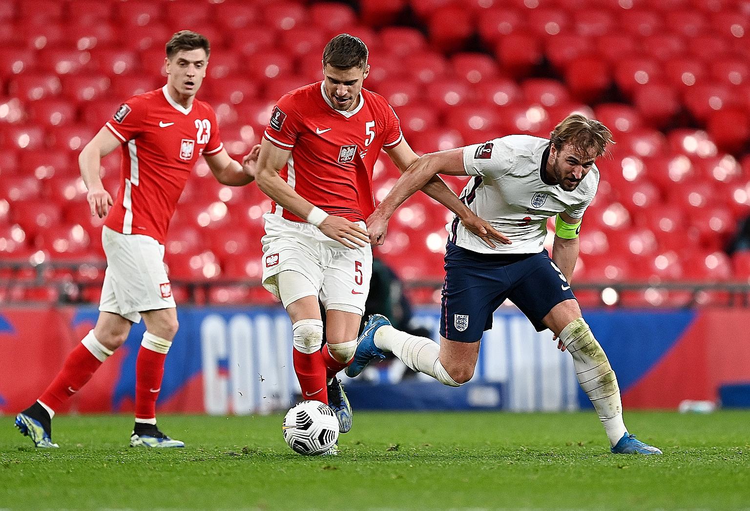 England's Harry Kane (in white) being tackled by Jan Bednarek of Poland at Wembley in March during a World Cup qualifier. Next month's delayed Euro 2020 marks the entry of OTT streaming service LiveNow into the premium global football market. PHOTO: 