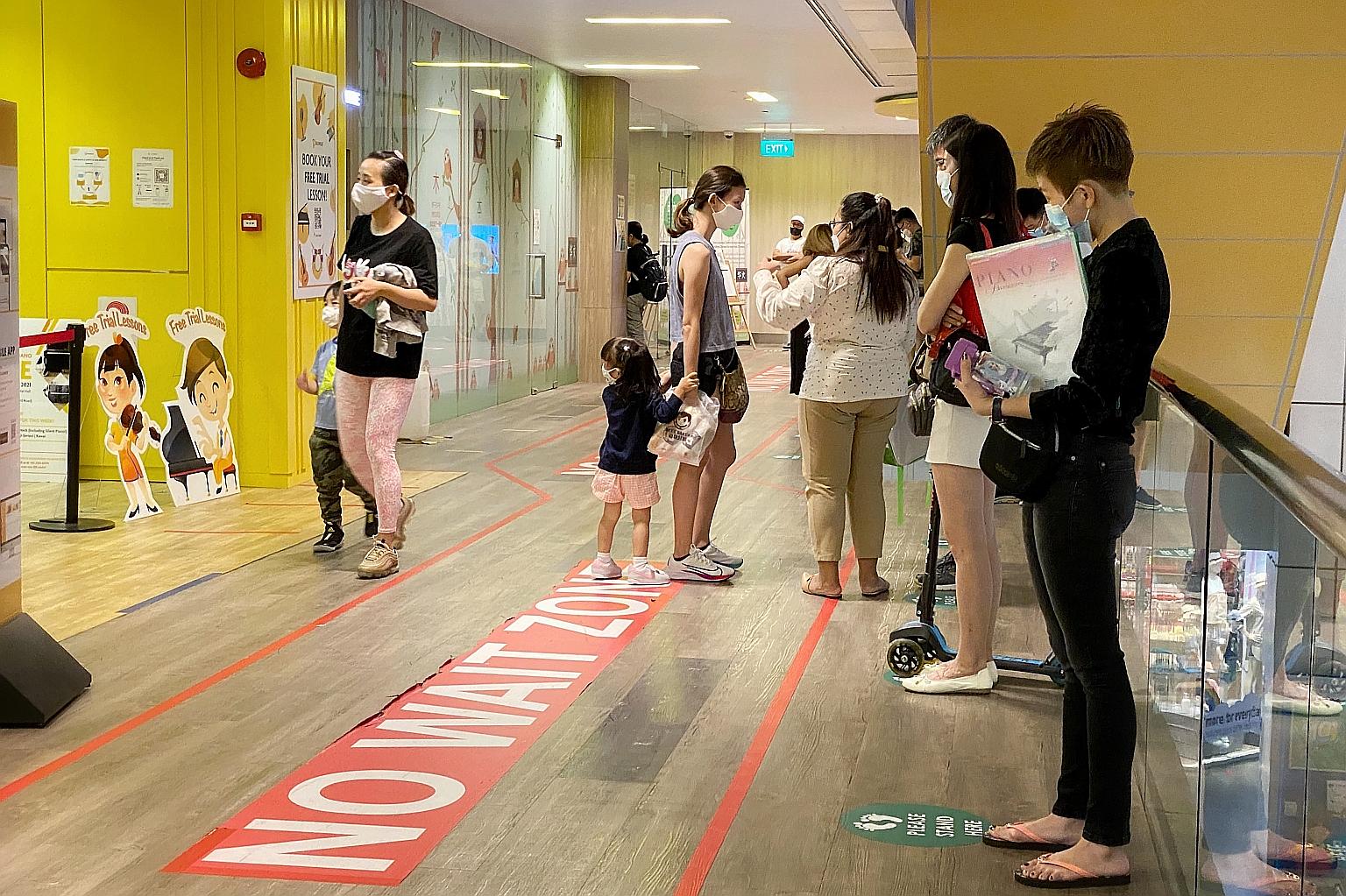 Parents and guardians waiting for their children attending enrichment classes at United Square mall on Saturday. Centres that are unable to move their classes online will need to suspend them till June 13, said the Ministry of Education yesterday.