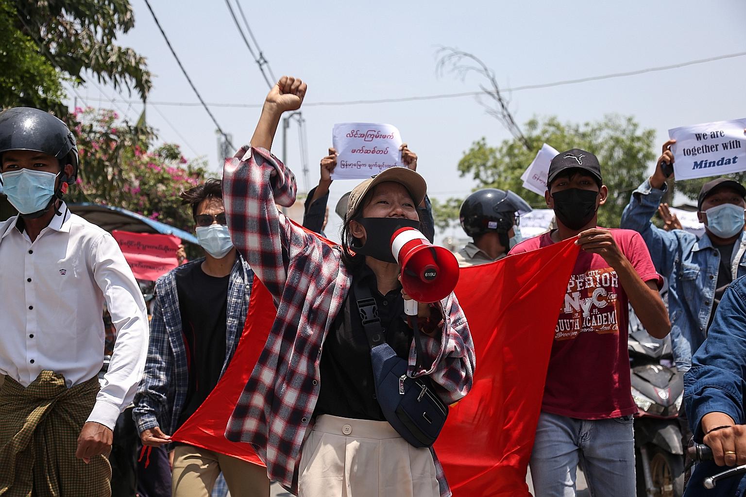 A demonstrator at an anti-coup protest in Mandalay, Myanmar, yesterday. A UN draft resolution urges the military in Myanmar to "end the state of emergency" and stop "all violence against peaceful demonstrators".