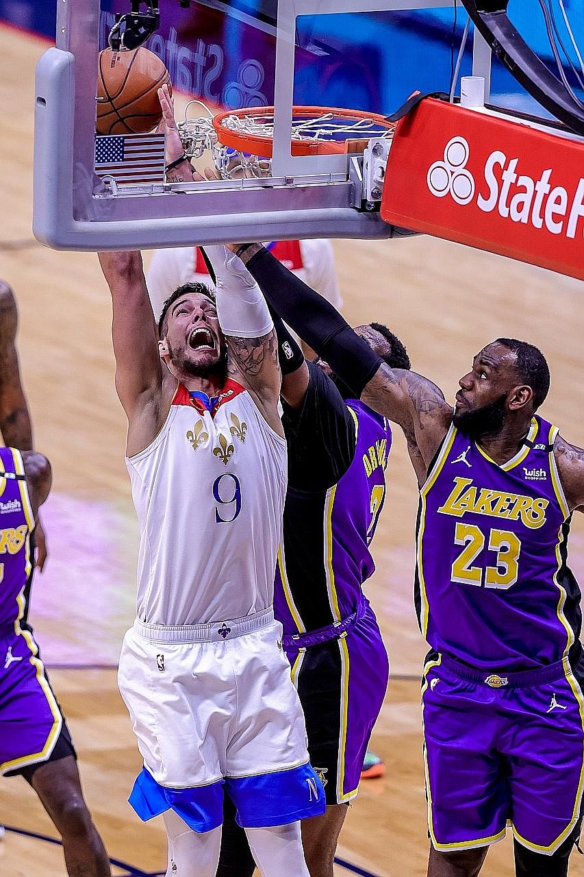 New Orleans Pelicans centre Willy Hernangomez being fouled by the Lakers' LeBron James at the Smoothie King Centre on Sunday. James had a game-high 25 points in their 110-98 win but they could not avoid the play-in.