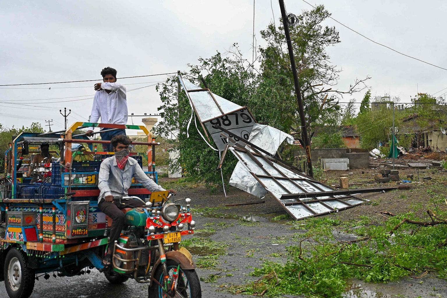 A motor rickshaw passing a billboard damaged by Cyclone Tauktae near Amreli in Gujarat yesterday. According to the Indian Meteorological department, the cyclone was categorised as "extremely severe" but has weakened to a "very severe" storm after mak